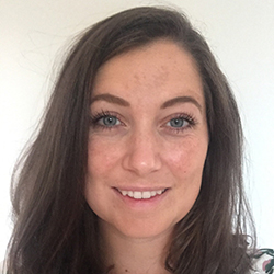En smilende kvinne med langt brunt hår og klare blå øyne, som utstråler varme og selvtillit, er Emmy Johanne Lundgaard Eilertsen.