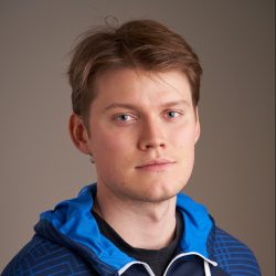 Portrett av Sondre Solbakken med rufsete hår, med et kontemplativt uttrykk og iført en blåmønstret jakke.