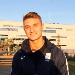 Smilende ung idrettsutøver nyter en solrik dag på campus.
